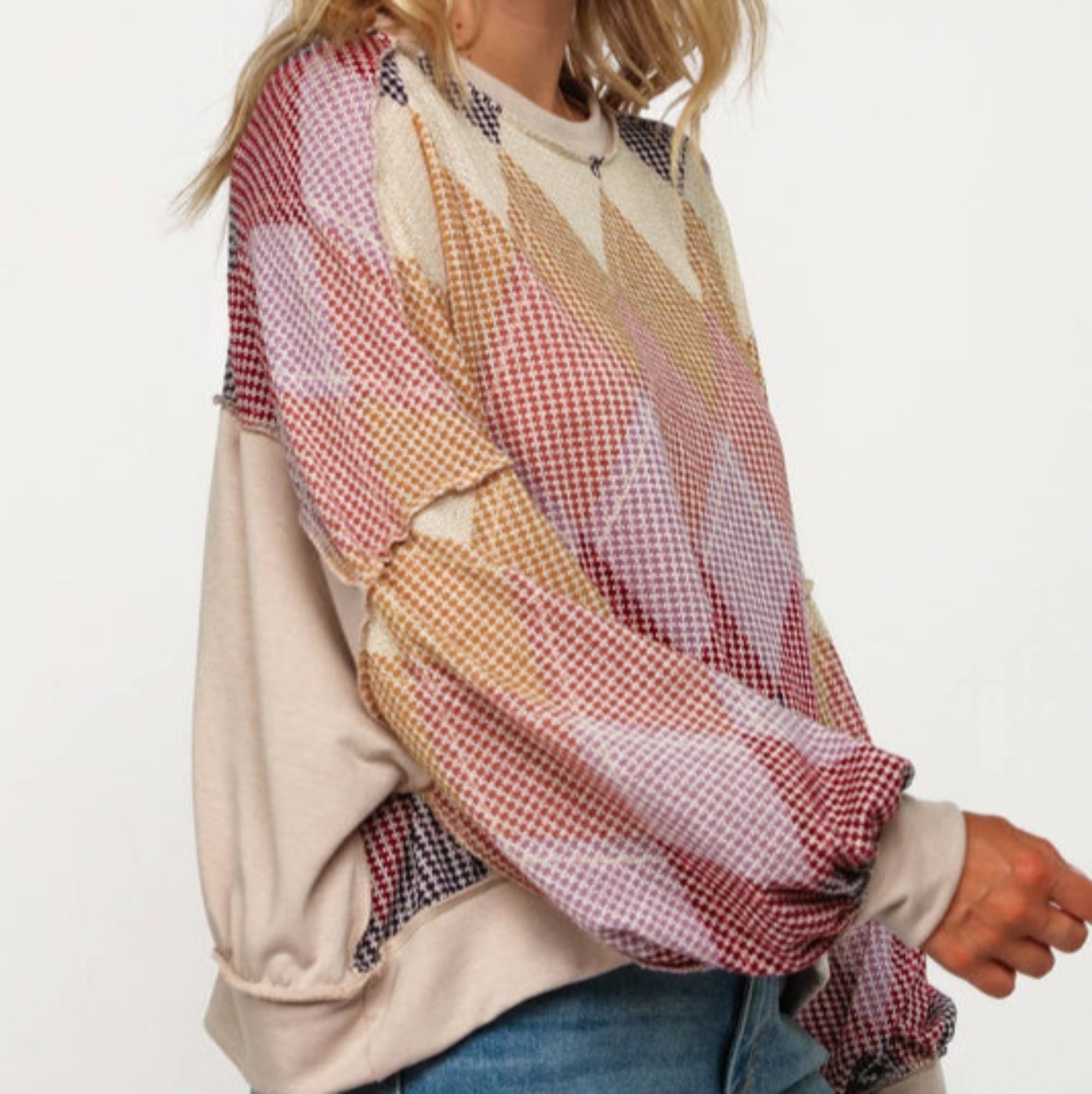 Woman wearing a colorful patterned blouse with a plain background