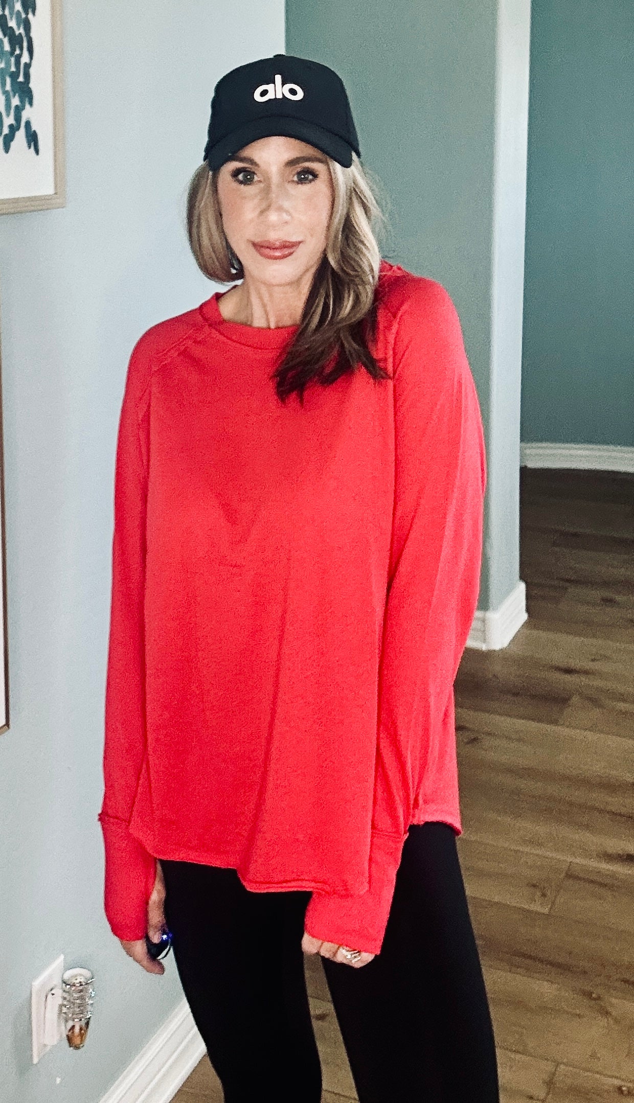 Women’s red long sleeve top with relaxed fit and scoop neckline.