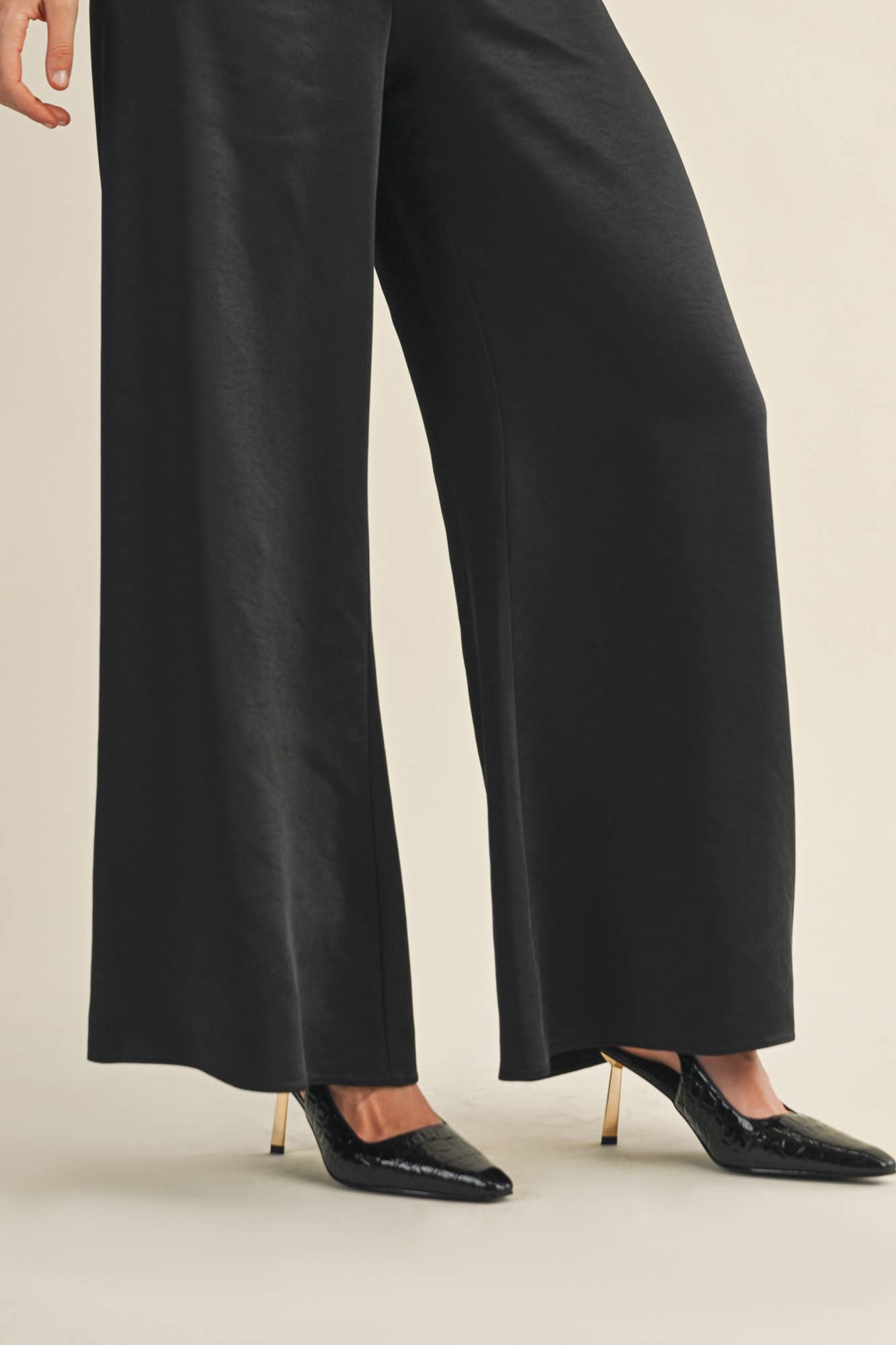 Women’s black satin wide-leg pants with high-rise fit and back zipper.